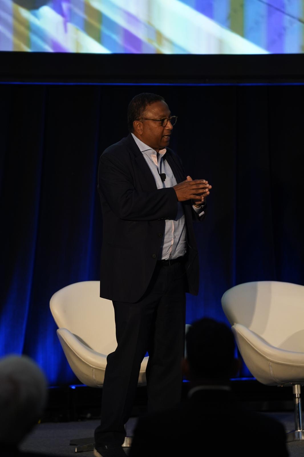 Suvajit Basu speaking on stage to enterprise leaders and boards